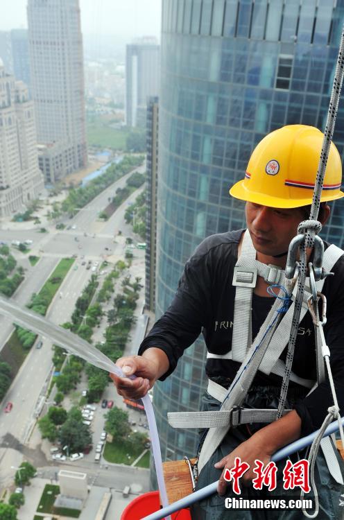 'Spidermen' clean windows of 303-meter-high skyscraper in Nanchang