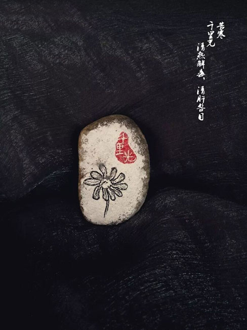 Doctor draws traditional Chinese medicines on stones