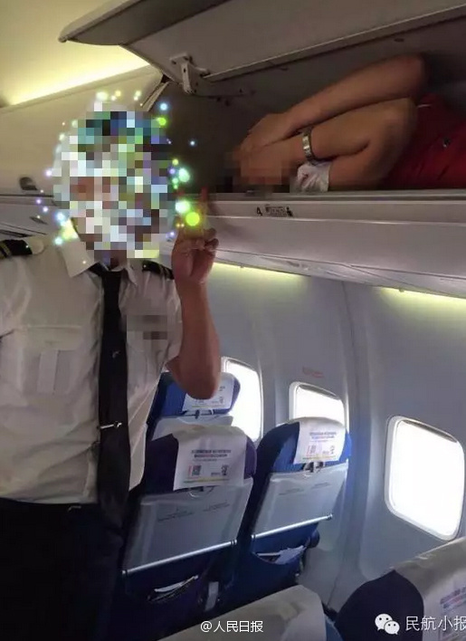 Air stewardesses packed into overhead bin