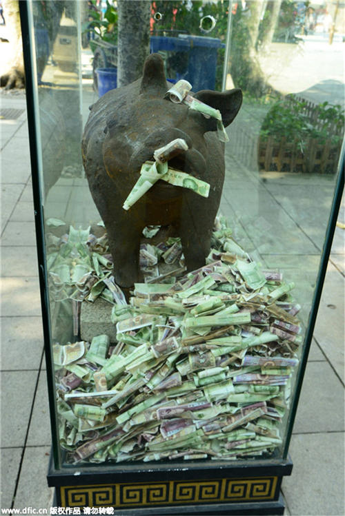 Bronze statues in Guangzhou scenic spot “swallowed” by banknotes and coins