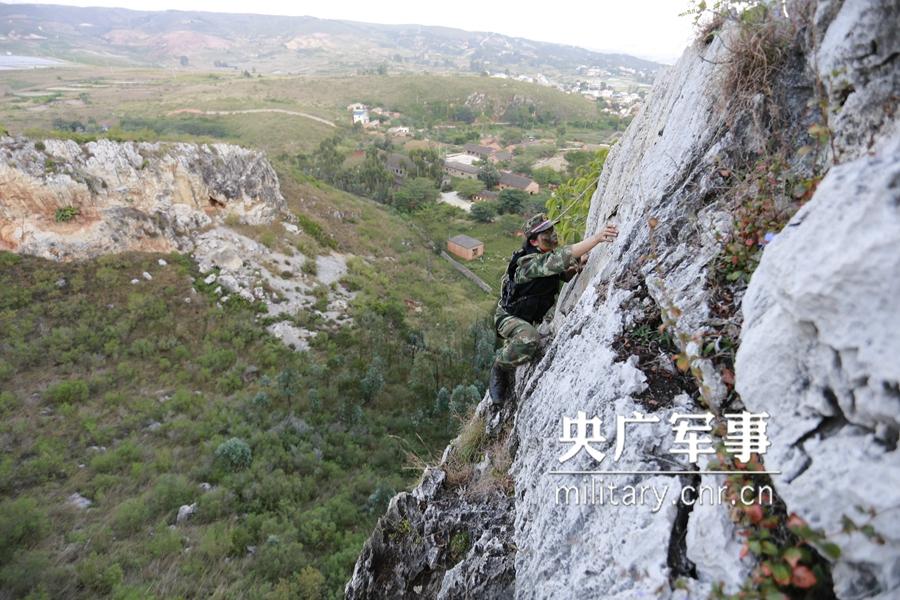 Female soldier of armed police force climbs cliff barehanded