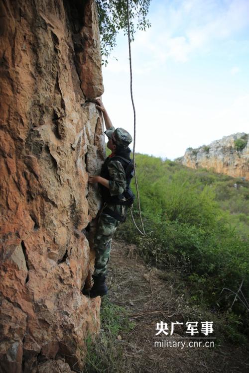 Female soldier of armed police force climbs cliff barehanded