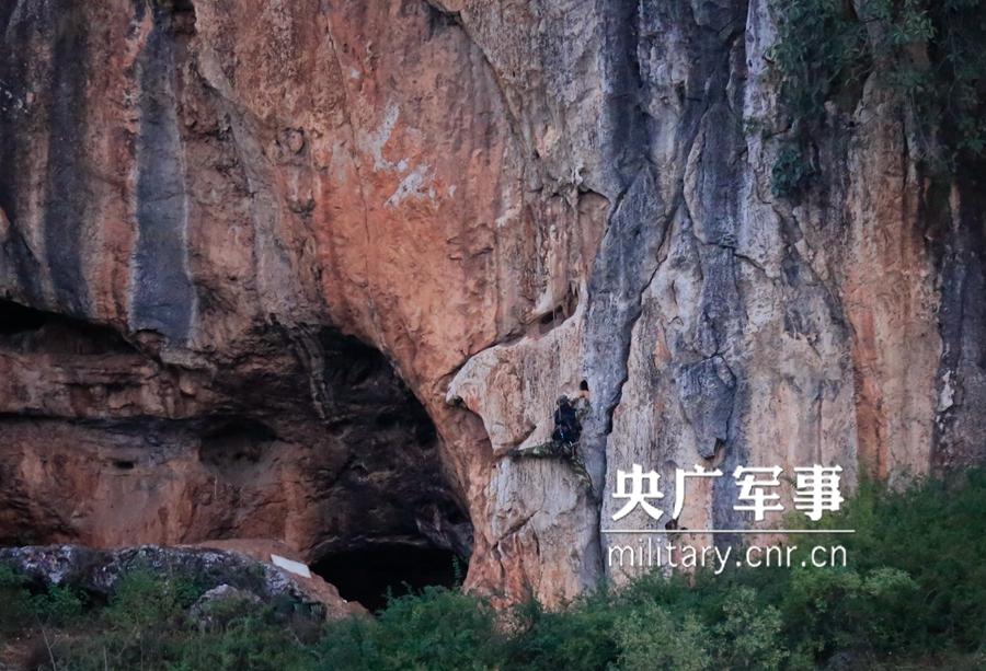 Female soldier of armed police force climbs cliff barehanded