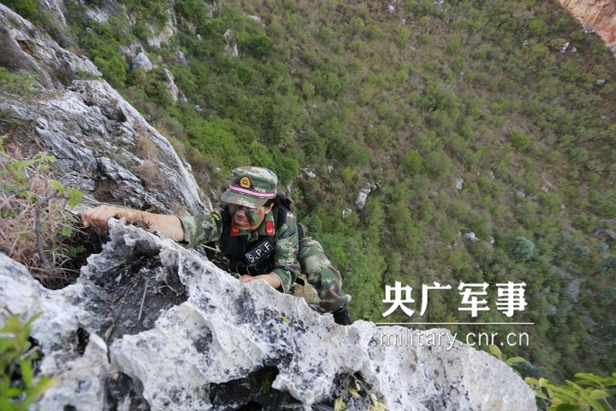 Female soldier of armed police force climbs cliff barehanded