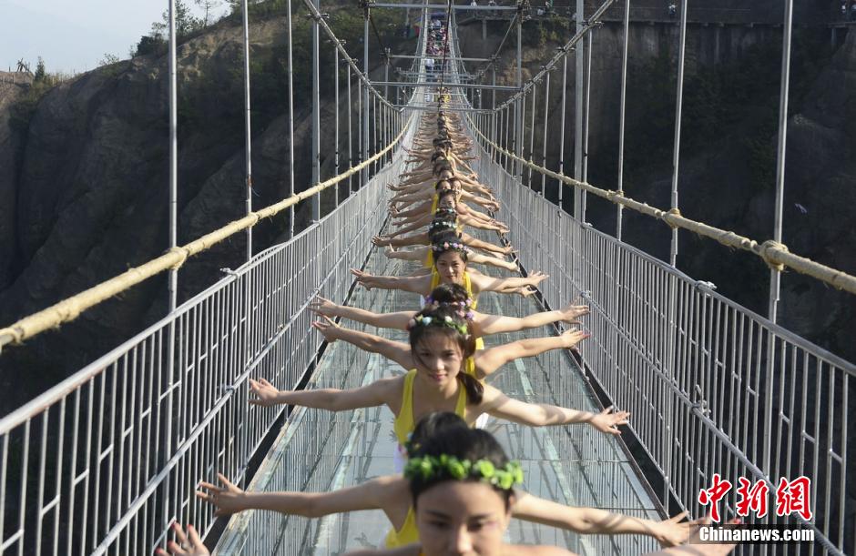 100 people perform yoga on 180-meter-high glass bridge 