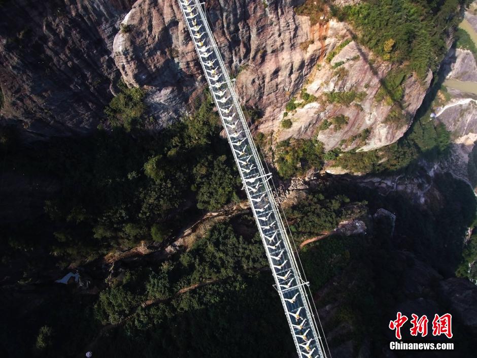 100 people perform yoga on 180-meter-high glass bridge 