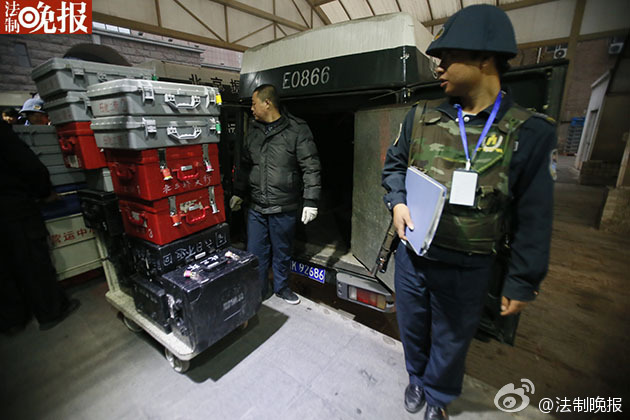 43 armored cash-in-transit vans wait in line to transport new 100-yuan banknotes