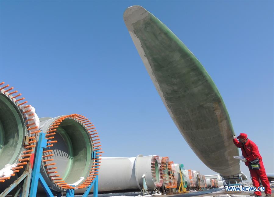 Quality control personnels examine wind-power blades in E China