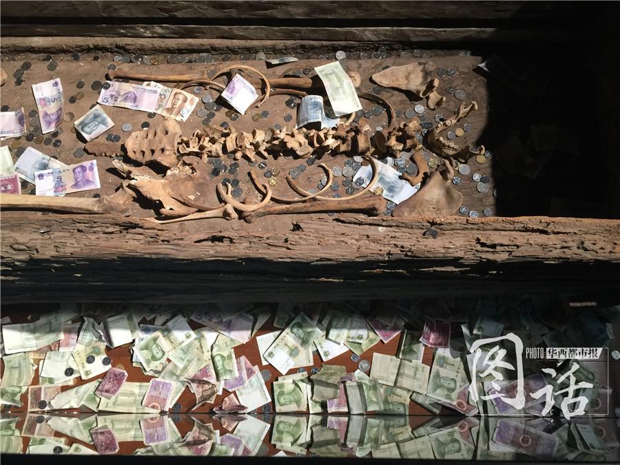 Human remains in museum covered by coins and banknotes thrown by tourists