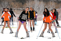 Beautiful skiers wear shorts in snow