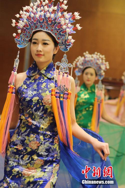 Models wearing phoenix coronet and cheongsam go down the runway