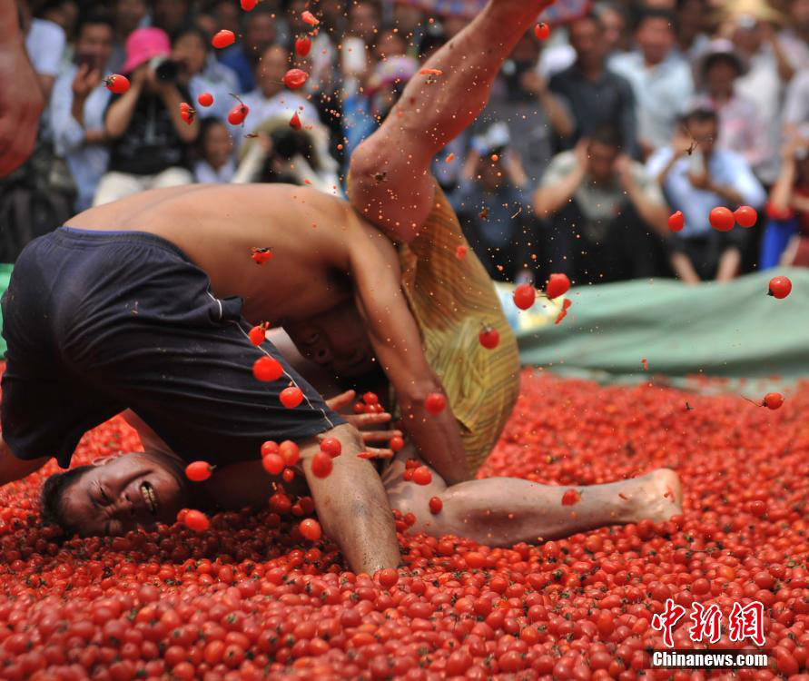 Zhuang people wrestle in pool of cherry tomatoes