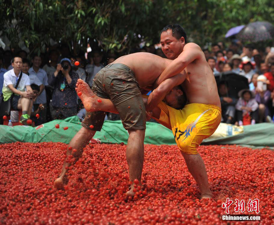 Zhuang people wrestle in pool of cherry tomatoes