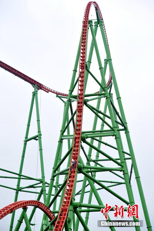 Man successfully climbs up 77-meter-high roller coaster