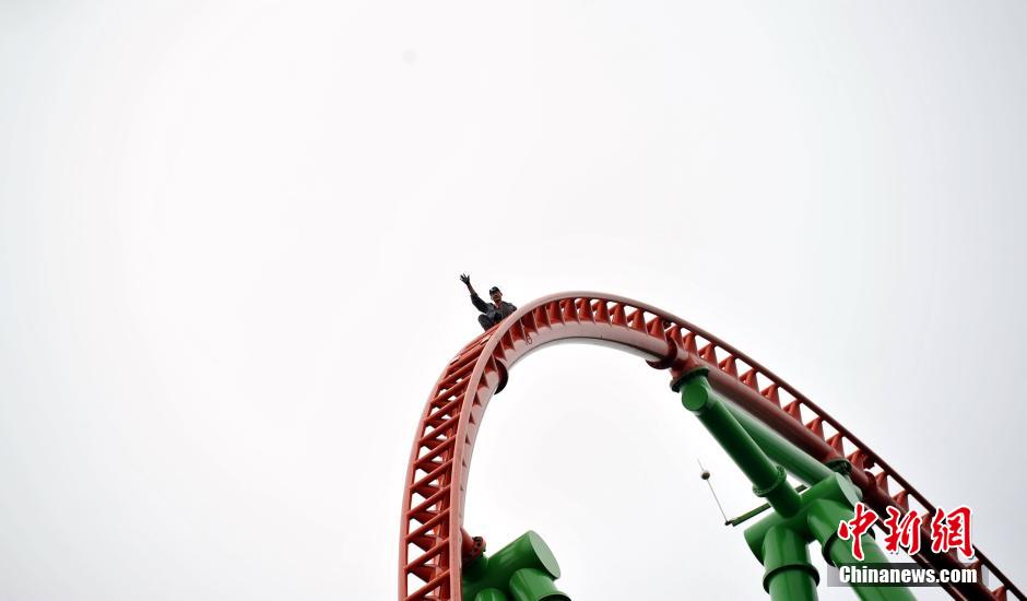 Man successfully climbs up 77-meter-high roller coaster