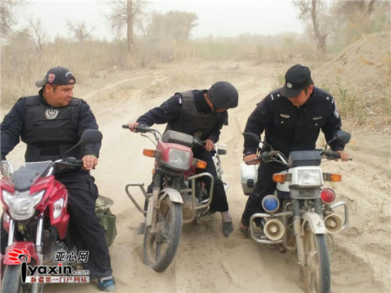 Braving dust and wind, policemen in the desert ride motorcycles to perform duty