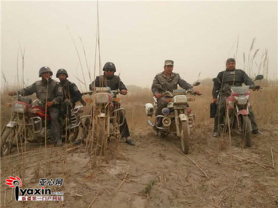 Braving dust and wind, policemen in the desert ride motorcycles to perform duty