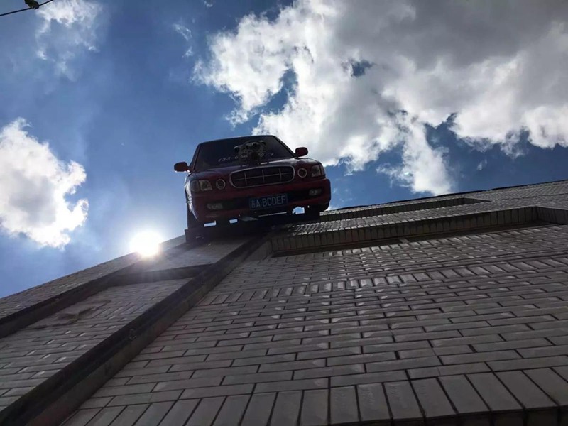 Man suspends car on outer wall of building