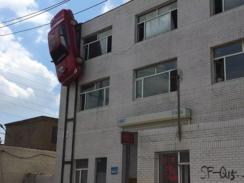 Man suspends car on outer wall of building