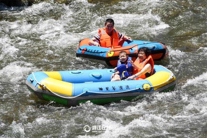 Tourists drift along river in Zhejiang scenic area