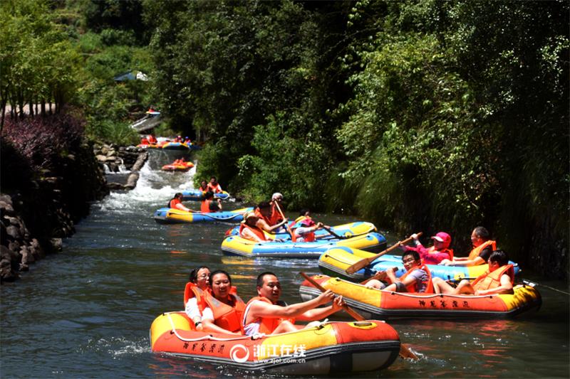 Tourists drift along river in Zhejiang scenic area