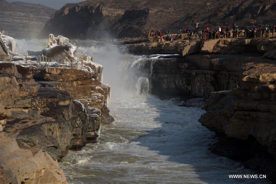 Visitors view frozen Hukou Waterfall on Yellow River