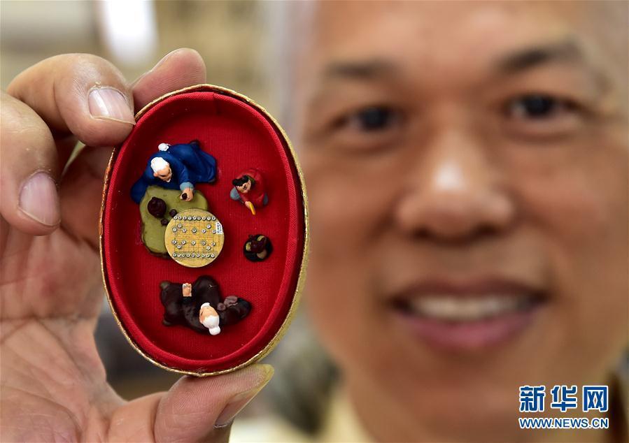 Man engraves miniscule Chinese chess board on tiny copper sheet