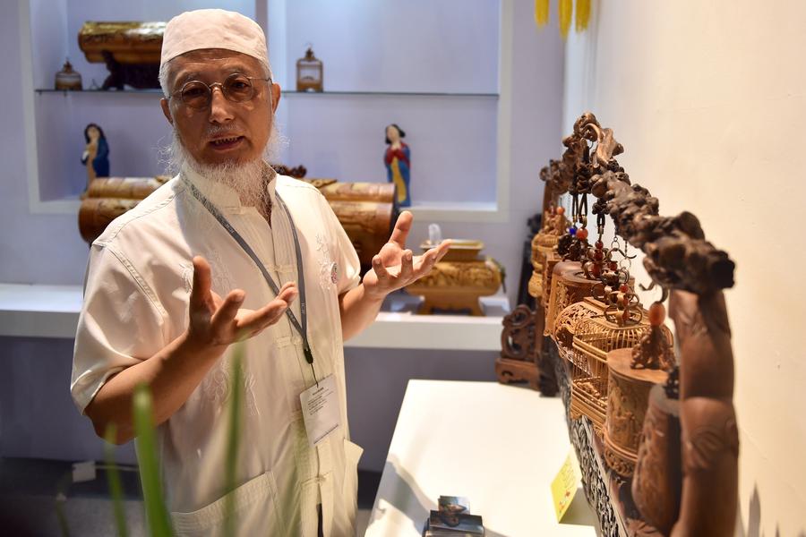 Cultural inheritor Wu Yunsheng introduces his bamboo carvings at the 13th China (Shenzhen) International Cultural Industries Fair in Shenzhen, South China's Guangdong province, May 11, 2017. The 5-day fair started on May 11, attracting 2,302 exhibitors. (Photo/Xinhua)