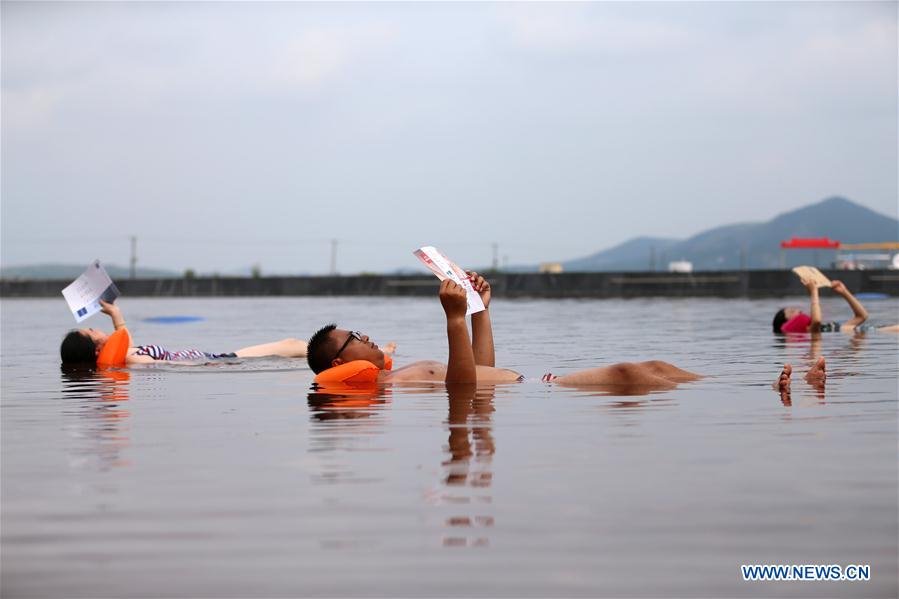 People bath in water with high amount of salt at resort in NE China