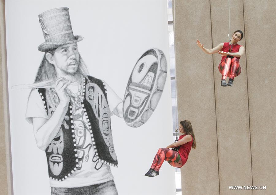 Dancers perform in air on exterior wall of Vancouver Public Library