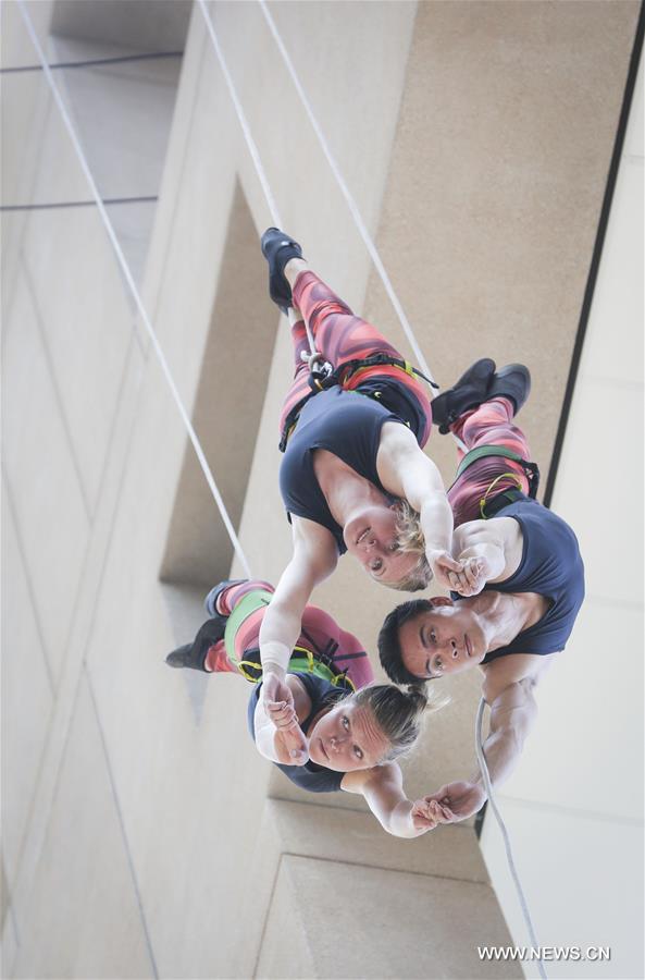 Dancers perform in air on exterior wall of Vancouver Public Library