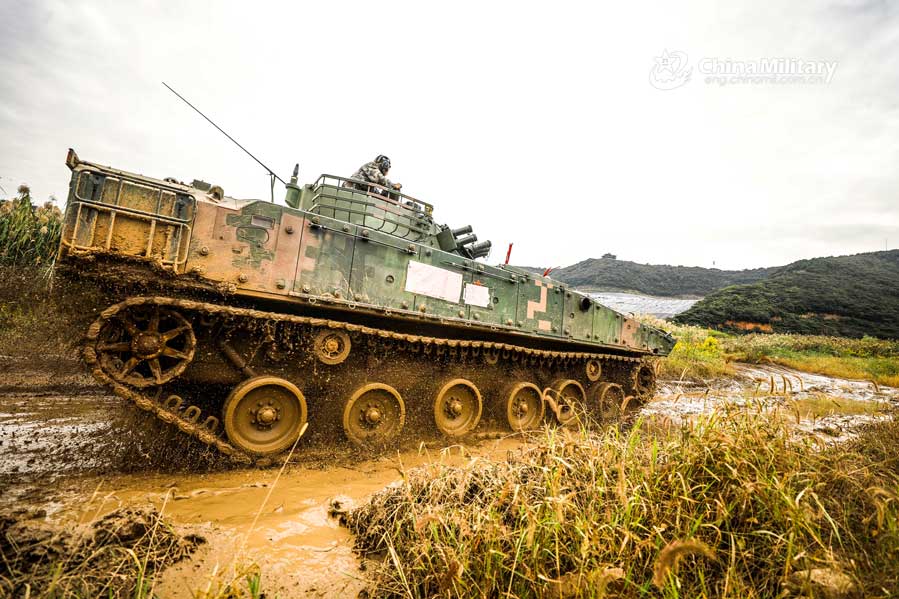 Infantry fighting vehicles drive through mire