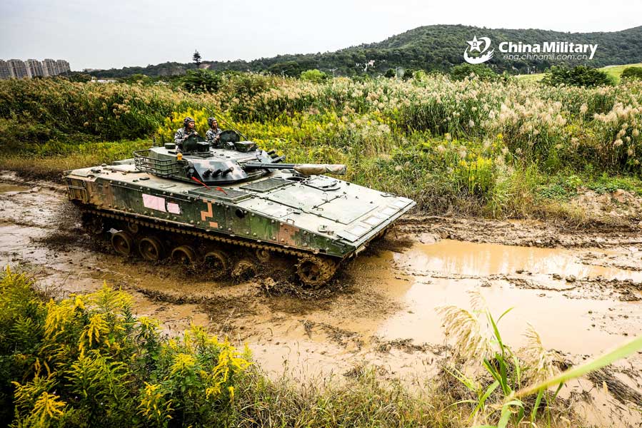 Infantry fighting vehicles drive through mire