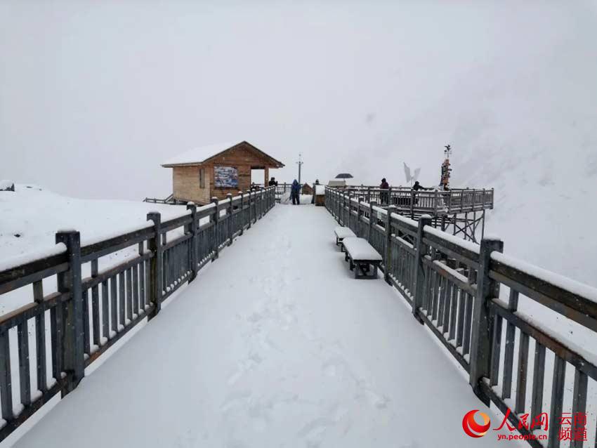 Visitors enjoy the beautiful snow-covered landscape at Yulong Snow Mountain, Oct. 21, 2020. (Photo/He Guichang)