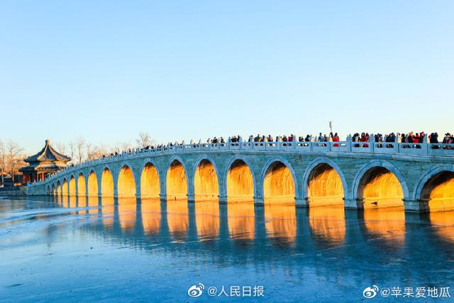 Stunning view of ancient bridge lit by golden winter sunshine at the Summer Palace in Beijing