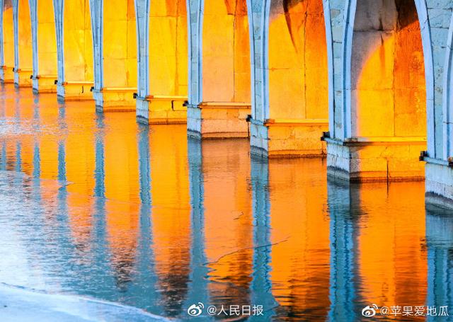 Stunning view of ancient bridge lit by golden winter sunshine at the Summer Palace in Beijing