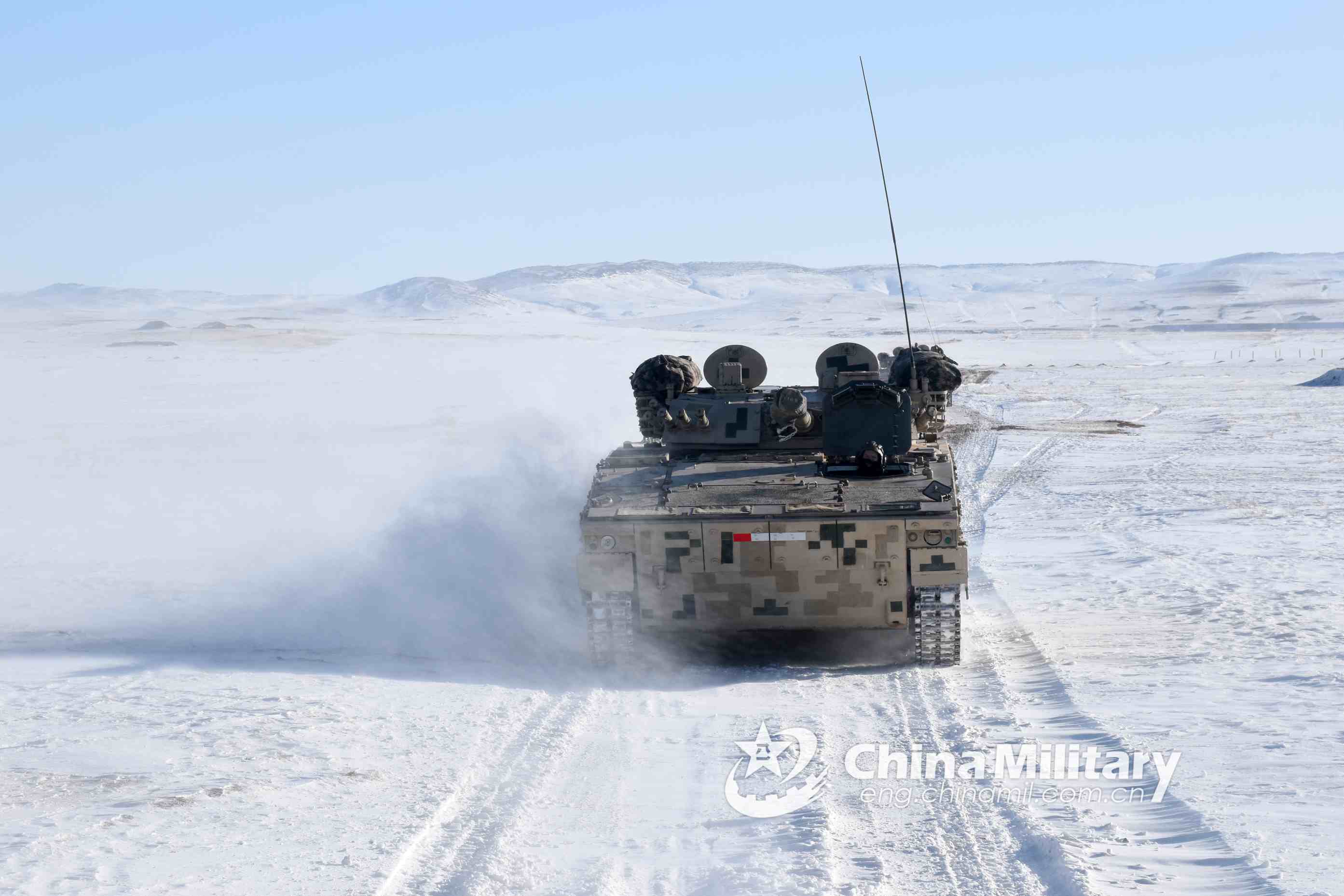 Soldiers drive armored vehicles on snow ground