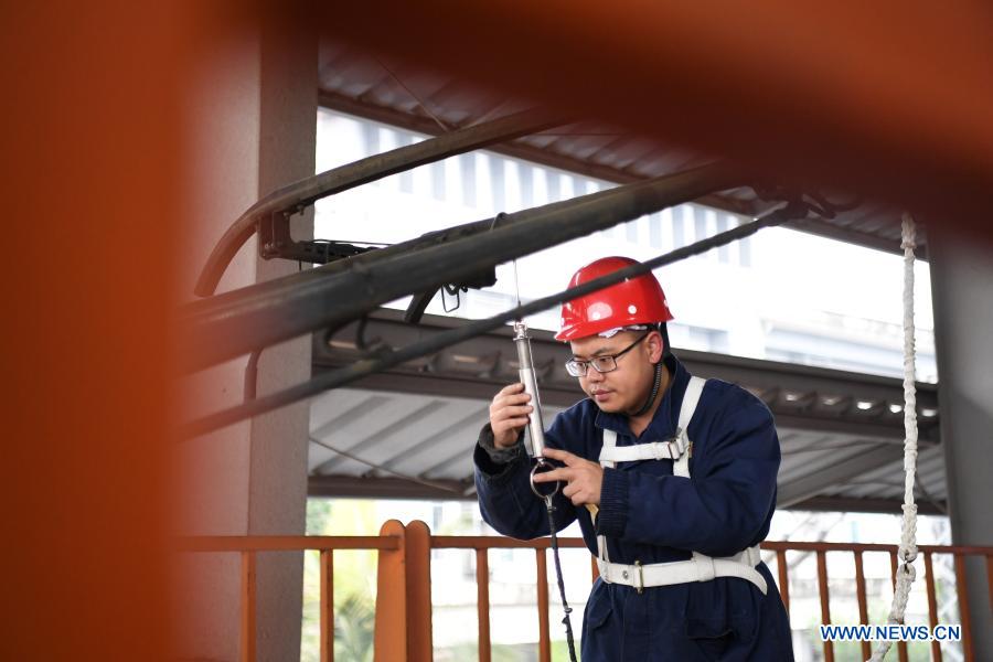 A technician maintains a train at workshop at Chongqing passenger section of China Railway Chengdu Group Co., Ltd. in Chongqing, southwest China, Jan. 26, 2021. Chongqing passenger section of China Railway Chengdu Group Co., Ltd. carries out maintenance works for the key parts of trains to prepare for the country's annual Spring Festival travel rush. (Xinhua/Tang Yi)