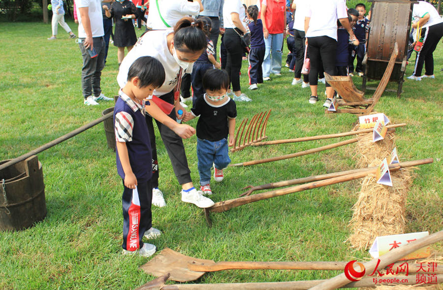 Children get hands-on experience using traditional farm tools in Tianjin, N China