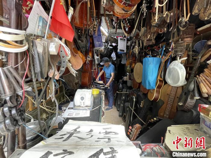 Corner street musical instrument repair shop becomes a popular site for visitors in Shanghai