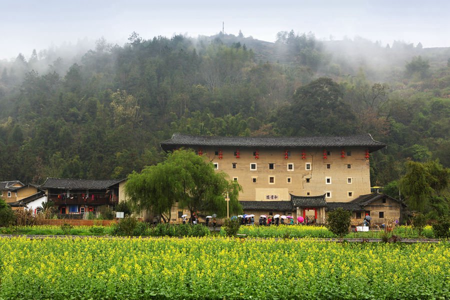 Blooming flowers freshen up age-old earthen buildings in SE China’s Fujian Province