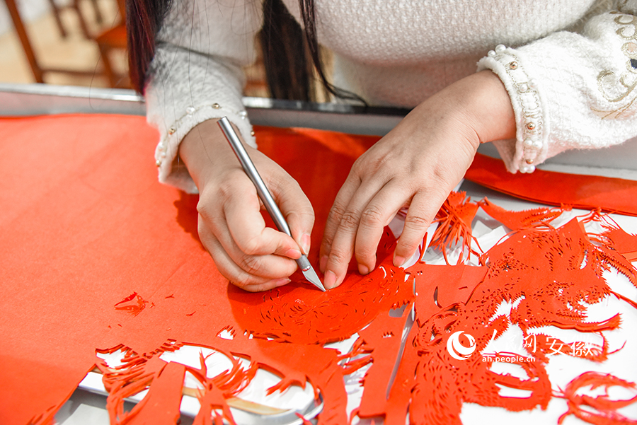 Craftswoman from E China's Anhui carries forward paper cutting culture with passion, devotion