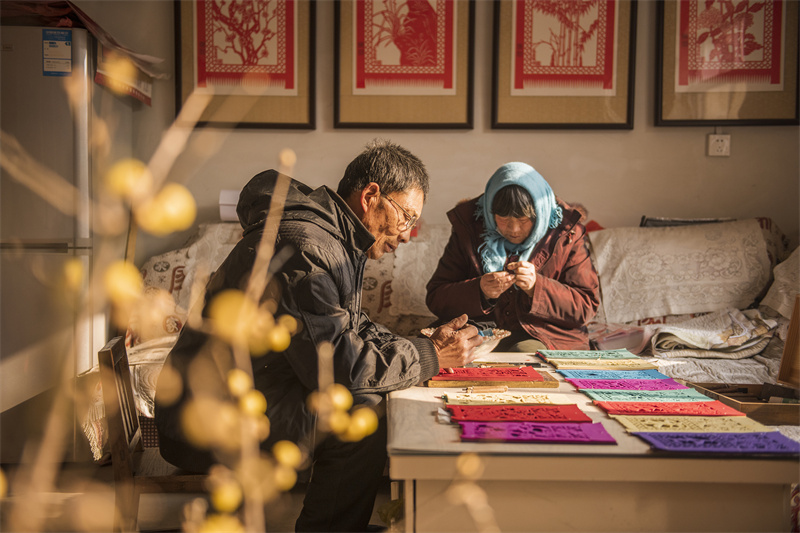 Folk artist creates Spring Festival paper carving works in E China's Shandong