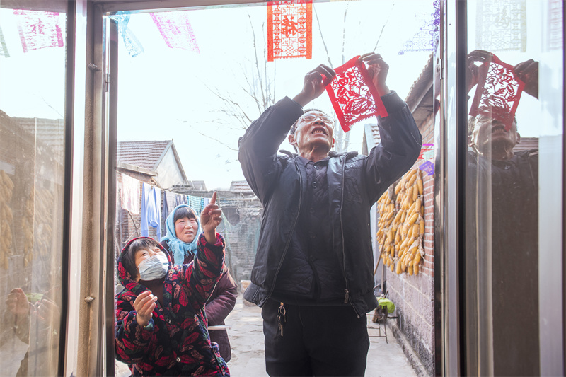 Folk artist creates Spring Festival paper carving works in E China's Shandong