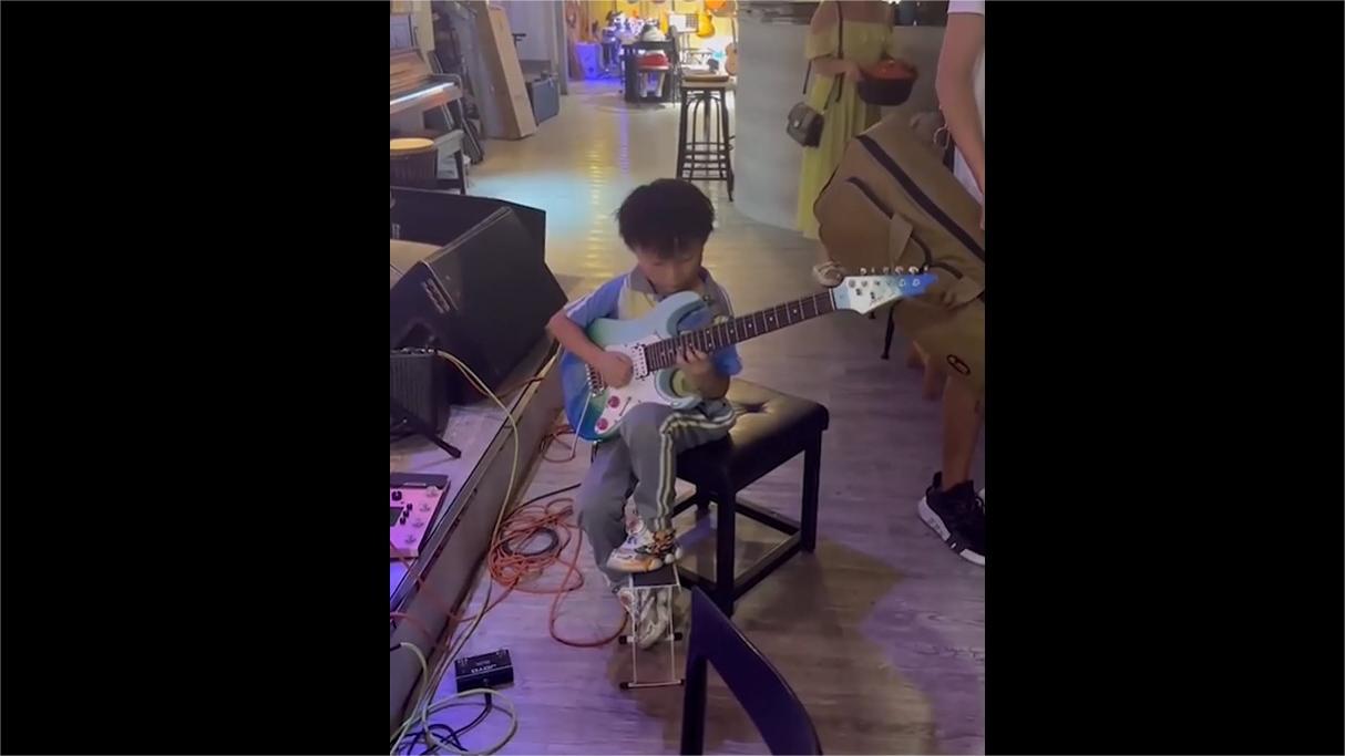 Small boy can sure play guitar