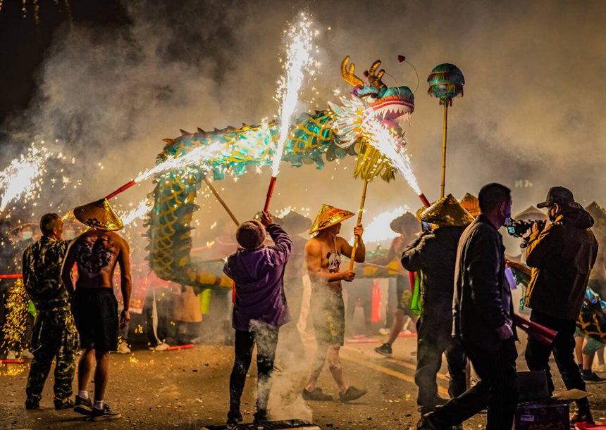 People perform firecracker dragon dance in S China's Guangxi