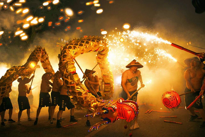 People perform firecracker dragon dance in S China's Guangxi