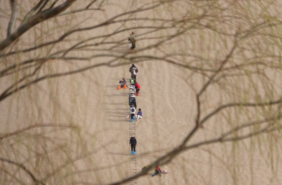 Tourists enjoy picturesque spring views of desert in Dunhuang, NW China's Gansu