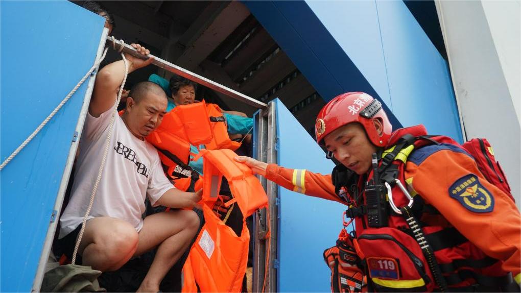 Firemen shoulder-lift trapped villagers after Hunan dike breach