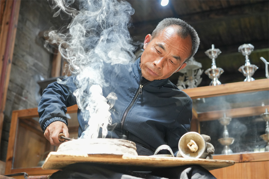 Inheritor passes on tin carving techniques in China's Jiangxi